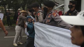 Massa yang tergabung dalam Aliansi Rakyat Menggugat (ARM) melakukan aksi unjuk rasa di sekitar Gedung Komisi Pemberantasan Korupsi (KPK), Jakarta, Kamis (13/1/2022). [Suara.com/Angga Budhiyanto]