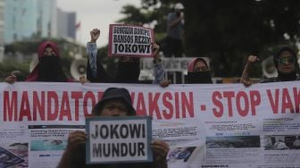 Massa yang tergabung dalam Aliansi Rakyat Menggugat (ARM) membawa spanduk dan poster saat melakukan aksi unjuk rasa di sekitar Gedung Komisi Pemberantasan Korupsi (KPK), Jakarta, Kamis (13/1/2022). [Suara.com/Angga Budhiyanto]