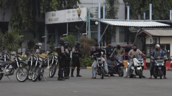 Anggota polisi melakukan simulasi pengamanan aksi balapan liar dalam upacara peresmian tim Perintis Presisi Polda Metro Jaya di Lapangan Presisi Polda Metro Jaya, Jakarta, Kamis (13/1/2022). [Suara.com/Angga Budhiyanto]