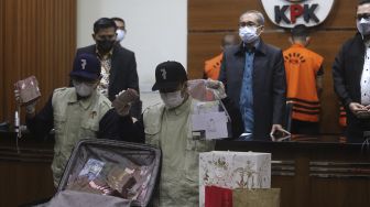 Penyidik menunjukkan barang bukti saat konferensi pers terkait operasi tangkap tangan (OTT) Bupati Penajam Paser Utara Abdul Gafur Mas'ud di Gedung Merah Putih KPK, Jakarta, Kamis (13/1/2021) malam. [Suara.com/Angga Budhiyanto]