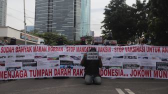 Massa yang tergabung dalam Aliansi Rakyat Menggugat (ARM) membawa spanduk dan poster saat melakukan aksi unjuk rasa di sekitar Gedung Komisi Pemberantasan Korupsi (KPK), Jakarta, Kamis (13/1/2022). [Suara.com/Angga Budhiyanto]