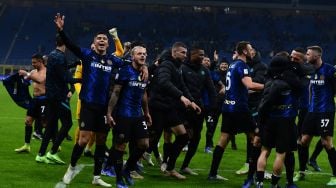 Para pemain Inter Milan merayakan dengan membawa trofi pemenang setelah memenangkan pertandingan sepak bola Piala Super Italia antara Inter melawan Juventus di Stadion Giuseppe-Meazza, Kamis (13/1/2022) dini hari WIB. [Foto AFP]