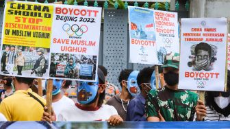 Poster-poster yang dibawa sejumlah massa aksi yang tergabung dalam Aliansi Mahasiswa Islam (AMI) saat menggelar aksi unjuk rasa di depan Kedutaan Besar China, Jakarta Selatan, Jumat (14/1/2022). [Suara.com/Alfian Winanto]