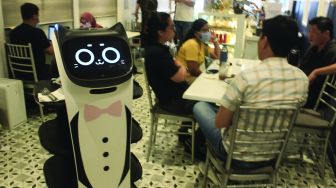 Pelayan robot melayani pelanggan di Rasa Koffie, Pasar Baru, Jakarta, Jumat (14/1/2022). [Suara.com/Septian]
