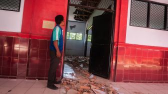 Petugas sekolah melihat kondisi ruang kelas yang rusak akibat gempa di SDN Kerta Mukti, Sumur, Pandeglang, Banten, Sabtu (15/1/2022).  ANTARA FOTO/Muhammad Bagus Khoirunas