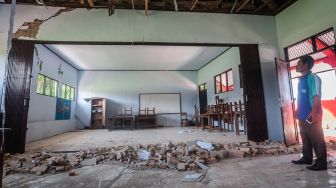 Petugas sekolah melihat kondisi ruang kelas yang rusak akibat gempa di SDN Kerta Mukti, Sumur, Pandeglang, Banten, Sabtu (15/1/2022).  ANTARA FOTO/Muhammad Bagus Khoirunas