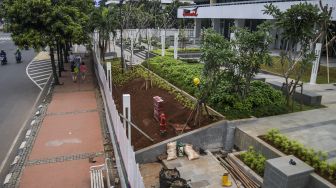 Warga melintas di samping proyek renovasi Gedung Sarinah di Jakarta, Sabtu (15/1/2022). ANTARA FOTO/Galih Pradipta
