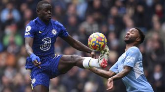 Bek Chelsea Malang Sarr (kiri) bersaing dengan gelandang Manchester City Raheem Sterling selama pertandingan sepak bola Liga Premier Inggris antara Manchester City dan Chelsea di Stadion Etihad, Manchester, Inggris, Sabtu (15/1/2022). [OLI SCARFF / AFP]