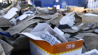 Sebuah kotak yang tidak digunakan tertinggal di bagian rel kereta Union Pacific yang dipenuhi dengan ribuan kotak dan paket terbuka yang dicuri dari kontainer pengiriman kargo di pusat Kota Los Angeles, California, Amerika Serikat, pada (14/1/2022). [PATRICK T. FALLON / AFP]