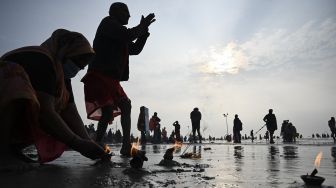 Peziarah Hindu melakukan ritual di pertemuan Sungai Gangga dan Teluk Benggala selama Gangasagar Mela pada kesempatan Makar Sankranti di Pulau Sagar, India, pada (14/1/2022). [DIBYANGSHU SARKAR / AFP]