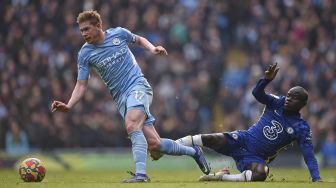 Gelandang Manchester City Kevin De Bruyne (kiri) menghindari tekel dari gelandang Chelsea N'Golo Kante selama pertandingan sepak bola Liga Premier Inggris antara Manchester City dan Chelsea di Stadion Etihad, Manchester, Inggris, Sabtu (15/1/2022). [OLI SCARFF / AFP]