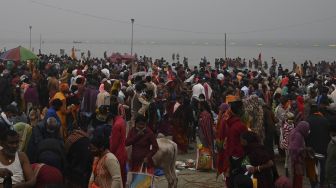 Peziarah Hindu melakukan ritual setelah berenang suci di pertemuan Sungai Gangga dan Teluk Benggala selama Gangasagar Mela pada kesempatan Makar Sankranti di Pulau Sagar, India, pada (14/1/2022). [DIBYANGSHU SARKAR / AFP]