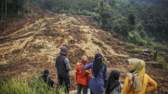 Warga menyaksikan tanah longsor di Desa Ciherang, Sumedang Selatan, Kabupaten Sumedang, Jawa Barat, Minggu (16/1/2022). [ANTARA FOTO/Raisan Al Farisi]