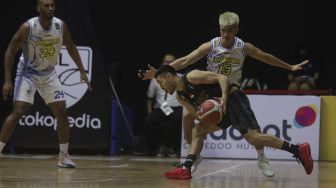 Pebasket West Bandits Combiphar Solo Widyanta Putra Teja berusaha melewati hadangan dari pebasket Prawira Bandung Hans Abraham pada pertandingan Seri 1 Jakarta Indonesian Basketball League (IBL) 2022 di Hall Basket Senayan, GBK, Jakarta, Senin (17/1/2022). [Suara.com/Angga Budhiyanto]