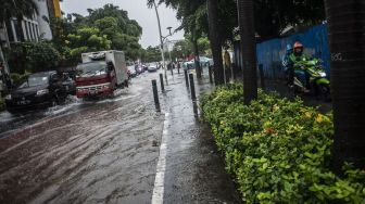 Kendaran melintasi genangan banjir di Jalan Cikini Raya, Jakarta, Selasa (18/1/2022).  ANTARA FOTO/Aprillio Akbar
