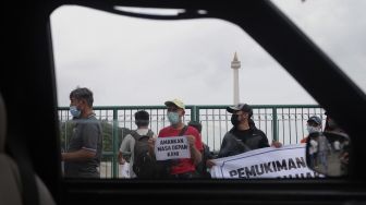 Pencari suaka asal Afghanistan melakukan aksi unjuk rasa di kawasan Monumen Nasional (Monas), Jakarta, Rabu (19/1/2022). [Suara.com/Angga Budhiyanto]