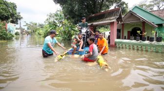 Warga melintasi banjir di Desa Rejoso, Kecamatan Rejoso, Pasuruan, Jawa Timur, Rabu (19/1/2022). ANTARA FOTO/Umarul Faruq
