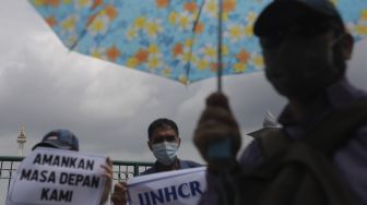Pencari suaka asal Afghanistan melakukan aksi unjuk rasa di kawasan Monumen Nasional (Monas), Jakarta, Rabu (19/1/2022). [Suara.com/Angga Budhiyanto]