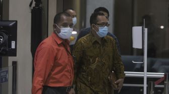 Hakim Pengadilan Negeri (PN) Surabaya Itong Isnaeni (kanan) berjalan menuju ruang pemeriksaan setibanya di Gedung Merah Putih KPK, Jakarta, Kamis (20/1/2022). [Suara.com/Angga Budhiyanto]