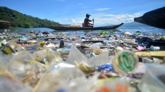 Nelayan mengayuh biduk di antara sampah di tepian Danau Singkarak, Nagari Sumpu, Kabupaten Tanah Datar, Sumatera Barat, Kamis (20/1/2022).  ANTARA FOTO/Iggoy el Fitra