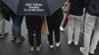 Massa yang tergabung dalam Jaringan Solidaritas Korban untuk Keadilan (JSKK) melakukan aksi Kamisan Ke-714 di seberang Istana Merdeka, Jakarta, Kamis (20/1/2022). [Suara.com/Angga Budhiyanto]