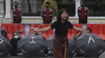 Polisi melakukan penjagaan aksi Kamisan Ke-714 di seberang Istana Merdeka, Jakarta, Kamis (20/1/2022). [Suara.com/Angga Budhiyanto]