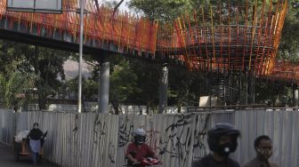 Sejumlah kendaraan melintas di bawah jembatan penghubung taman selatan dan utara pada revitalisasi Taman Tebet menjadi Tebet Eco Garden di Jalan Tebet Timur Raya, Jakarta, Jumat (21/1/2022). [Suara.com/Angga Budhiyanto]