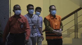 Hakim Pengadilan Negeri (PN) Surabaya Itong Isnaini Hidayat (kanan) berjalan menuju ruang konferensi pers usai menjalani pemeriksaan terkait operasi tangkap tangan (OTT) di Gedung Merah Putih KPK, Jakarta (20/1/2022) malam. [Suara.com/Angga Budhiyanto]