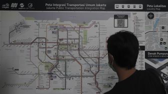 Warga mengamati papan petunjuk arah atau &#039;wayfinding&#039; di Halte Integrasi CSW, Kebayoran Baru, Jakarta, Jumat (21/1/2022). [Suara.com/Angga Budhiyanto]