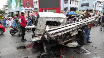 Warga mengamati sebuah mobil yang rusak akibat ditabrak truk tronton di Turunan Rapak, Balikpapan, Kaltim, Jumat (21/1/2022). [ANTARA FOTO]