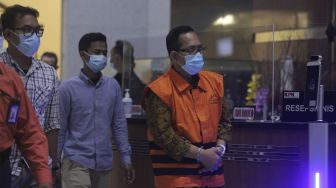 Hakim Pengadilan Negeri (PN) Surabaya Itong Isnaini Hidayat (kanan) berjalan menuju ruang konferensi pers usai menjalani pemeriksaan terkait operasi tangkap tangan (OTT) di Gedung Merah Putih KPK, Jakarta (20/1/2022) malam. [Suara.com/Angga Budhiyanto]