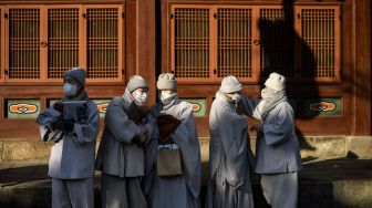 Anggota Ordo Jogye, sekte Buddha terbesar di Korea Selatan, mengobrol usai menghadiri rapat umum di Kuil Jogye, Seoul, Jumat (21/1/2022). [ANTHONY WALLACE / AFP]