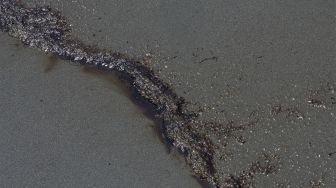 Tumpahan minyak terdampar di pantai di Provinsi Callao, Peru, pada (17/1/2022). [CRIS BOURONCLE / AFP]