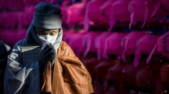 Seorang Biksu dari Ordo Jogye, sekte Buddha terbesar di Korea Selatan, berdoa saat menghadiri rapat umum di Kuil Jogye, Seoul, Jumat (21/1/2022). [ANTHONY WALLACE / AFP]
