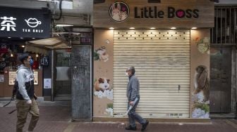 Orang-orang berjalan melewati toko hewan peliharaan tempat seorang karyawan dan pelanggannya kemudian dinyatakan positif COVID-19 setelah menangani hamster, di Causeway Bay, Hong Kong, pada (18/1/2022). [BERTHA WANG / AFP]