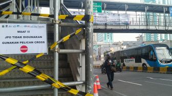 Jembatan Penyeberangan Orang (JPO) yang ditutup karena proses pembangunan di Kawasan Glodok, Jakarta Barat, Minggu (23/1/2022). [Suara.com/Alfian Winanto]