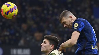 Penyerang Inter Milan Edin Dzeko (kanan) menyundul bola dan mencetak gol selama pertandingan sepak bola Serie A Italia antara Inter Milan melawan Venezia di Stadion Giuseppe Meazza, Sabtu waktu setempat atau Minggu (23/1/2022) dini hari WIB. Alberto PIZZOLI / AFP