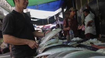 Pedagang menata ikan bandeng di kawasan Petak Sembilan, Glodok, Jakarta, Senin (24/1/2022). [Suara.com/Angga Budhiyanto]