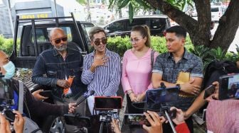 Artis Emma Waroka ditemani Kim Hawt menemui awak media saat datang untuk membuat laporan di Polda Metro Jaya, Jakarta Selatan, Senin (24/1/2022). [Suara.com/Alfian Winanto]