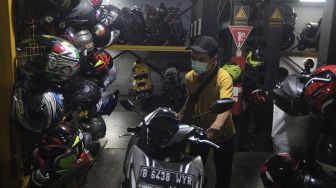 Pekerja mengeluarkan sepeda motor di Soul Parking, Kebon Kacang, Jakarta, Senin (24/1/2022). [Suara.com/Angga Budhiyanto]