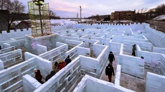 Pengunjung berjalan di Ice Palace Maze, Stillwater, Minnesota, Amerika Serikat, pada (21/1/2022). [KEREM YUCEL / AFP]
