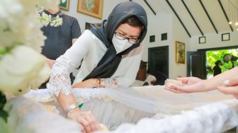 Aktris dan Politikus Nurul Arifin melihat peti jenazah putrinya, Maura Magnalia Madyaratri saat disemayamkan di rumah duka di Cinere, Depok, Jawa Barat, Selasa (25/1/2022). [Suara.com/Alfian Winanto]