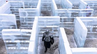 Seseorang berpakaian ksatria berbaju besi berjalan di Ice Palace Maze, Stillwater, Minnesota, Amerika Serikat, pada (21/1/2022). [KEREM YUCEL / AFP]