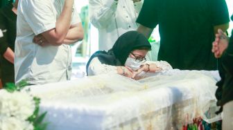 Aktris dan Politikus Nurul Arifin menangis di samping peti jenazah putrinya, Maura Magnalia Madyaratri saat disemayamkan di rumah duka di Cinere, Depok, Jawa Barat, Selasa (25/1/2022). [Suara.com/Alfian Winanto]