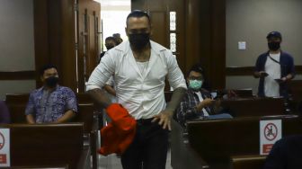 Musisi I Gede Ari Astina atau Jerinx SID memasuki ruang sidang untuk menjalani sidang lanjutan kasus pengancaman di Pengadilan Negeri Jakarta Pusat, Selasa (25/1/2022). [Suara.com/Alfian Winanto]