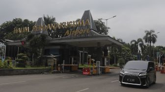 Sebuah mobil keluar dari kawasan Bandara Halim Perdanakusuma, Jakarta, Rabu (26/1/2022). [Suara.com/Angga Budhiyanto]