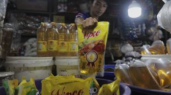 Pedagang menata minyak goreng kemasan di tokonya di Pasar Minggu, Jakarta, Rabu (26/1/2022). [Suara.com/Angga Budhiyanto]