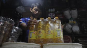 Pedagang menata minyak goreng kemasan di tokonya di Pasar Minggu, Jakarta, Rabu (26/1/2022). [Suara.com/Angga Budhiyanto]