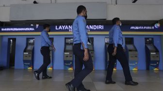 Petugas berjalan di area keberangkatan Bandara Halim Perdanakusuma, Jakarta, Rabu (26/1/2022). [Suara.com/Angga Budhiyanto]