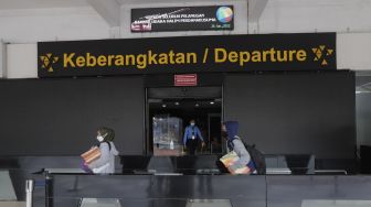 Petugas berjalan di area keberangkatan Bandara Halim Perdanakusuma, Jakarta, Rabu (26/1/2022). [Suara.com/Angga Budhiyanto]